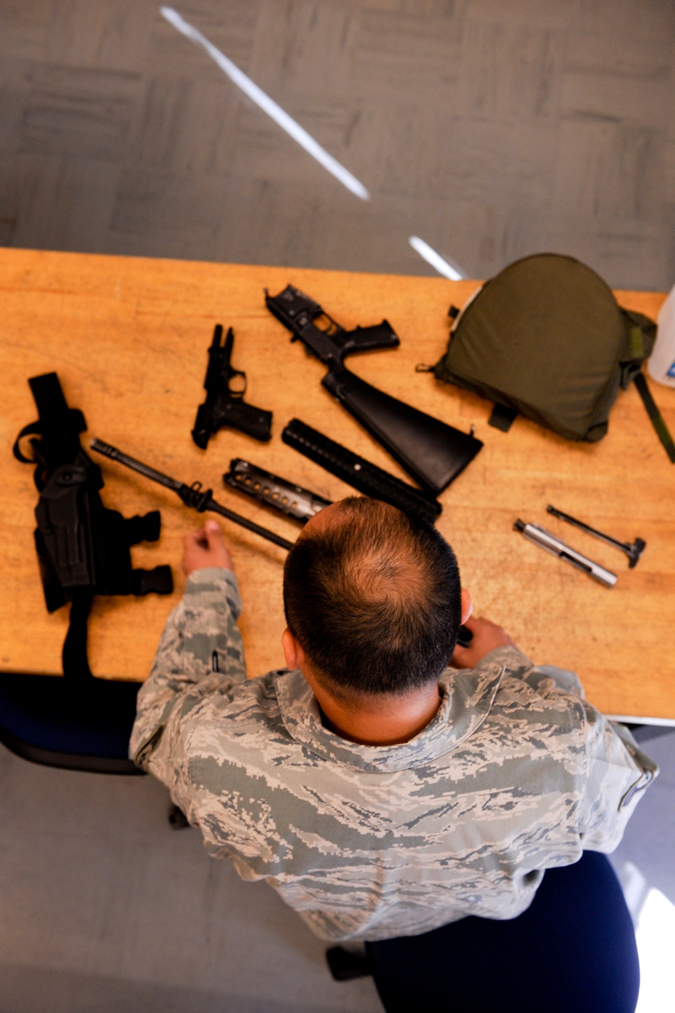 VANDENBERG AIR FORCE BASE, Calif. -- Staff Sgt. Bien Covita, a 30th Comptroller Squadron deputy dispersing officer, disassembles an M16 assault rifle during the first class of the new Rifle Carbine Air Force Qualification Course here Tuesday, Dec. 6, 2011. The new course, in which Airman fire nearly double the amount of rounds of the previous course, contains both basic firing positions (prone, sitting, kneeling, standing) and advanced tactical movements. (U.S. Air Force/Staff Sgt. Levi Riendeau)