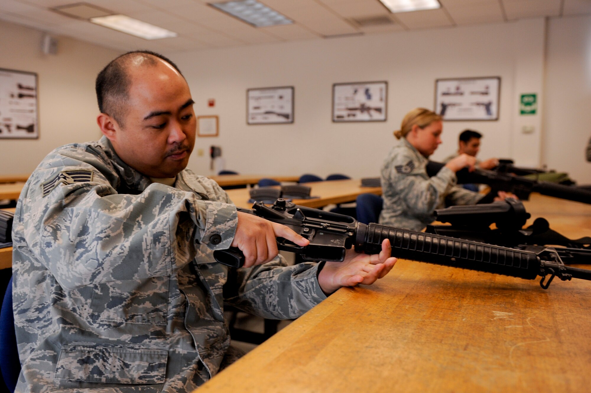 VANDENBERG AIR FORCE BASE, Calif. -- Staff Sgt. Bien Covita, a 30th Comptroller Squadron deputy dispersing officer, clears an M16 assault rifle during the first class of the new Rifle Carbine Air Force Qualification course here Tuesday, Dec. 6, 2011. The new course, in which Airman fire nearly double the amount of rounds of the previous course, contains both basic firing positions (prone, sitting, kneeling, standing) and advanced tactical movements. (U.S. Air Force/Staff Sgt. Levi Riendeau)