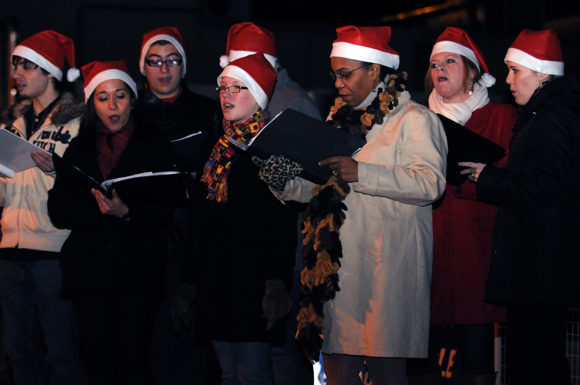 Carolers sing at the annual Christmas tree lighting ceremony  Dec. 7 at Aviano Air Base, Italy. The event also included a tree lighting countdown, Santa's arrival, and free cookies with hot chocolate. (U.S. Air Force photo/Airman 1st Class Jenay Randolph)