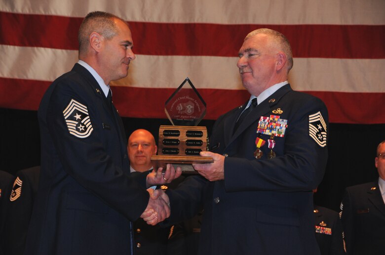 148th Fighter Wing Command Chief Master Sergeant Mark Rukavina accepts the Command Chief Plaque from retiring  Command Chief Master Sergeant Michael Layman during a Transfer of Authority cermony that was held Dec. 4, 2011 in Duluth, Minn.  The Command Chief plaque is symbolic of the authority the incumbant holds while ating in this prestigiuos role.   National Guard photo by Tech. Sgt. Brett Ewald)