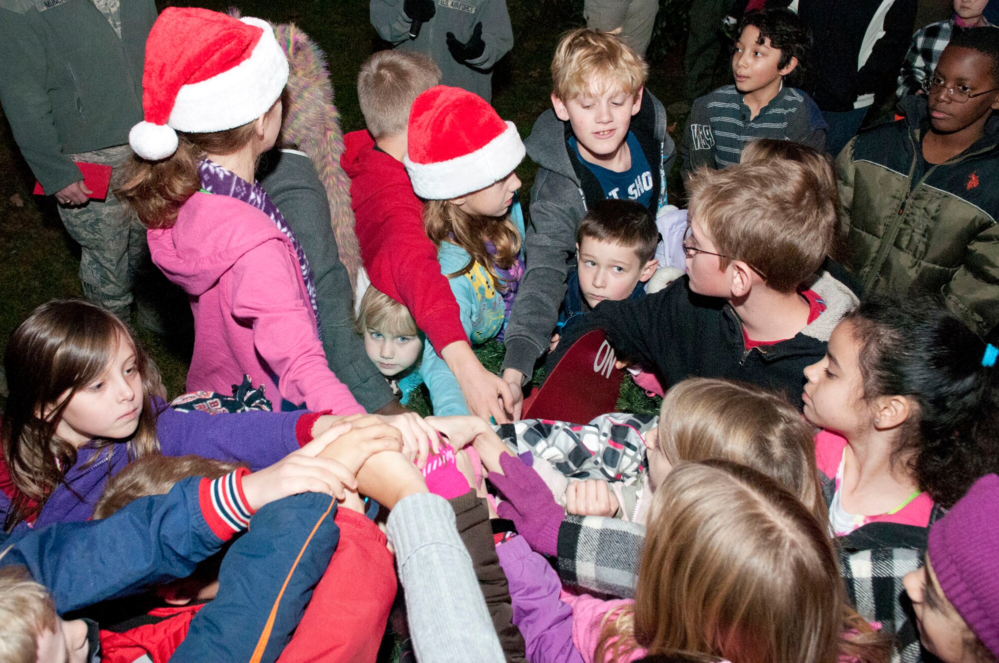 HANSCOM AIR FORCE BASE, Mass. – Children squeeze in for a chance to pull the switch to light the tree during the Christmas Tree Lighting ceremony at the base chapel Dec. 1. The event also included performances by the Hanscom Bell Choir and Band of Liberty, as well as a chance enjoy refreshments and take photos with Santa.(U.S. Air Force photo by Mark Wyatt)