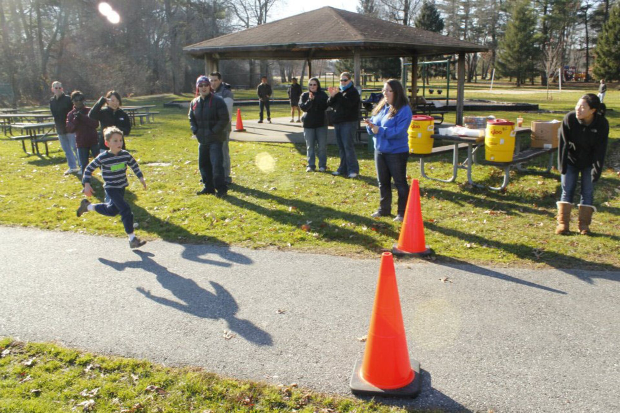 HANSCOM AIR FORCE BASE, Mass. – Jonathan Amirault crosses the finish line to win first place in the 6-8 year old category and as overall winner at the Holiday Run for Kids held Dec. 3 at Castle Park. Other category winners included Douglas Amirault from the 9-12 year olds and Grace McCaa in the 4-5 year old category. The Hanscom Company Grade Officers Council, along with many volunteers from across the base, organized the run to raise money for military families in need during the holiday season. (Courtesy photo)