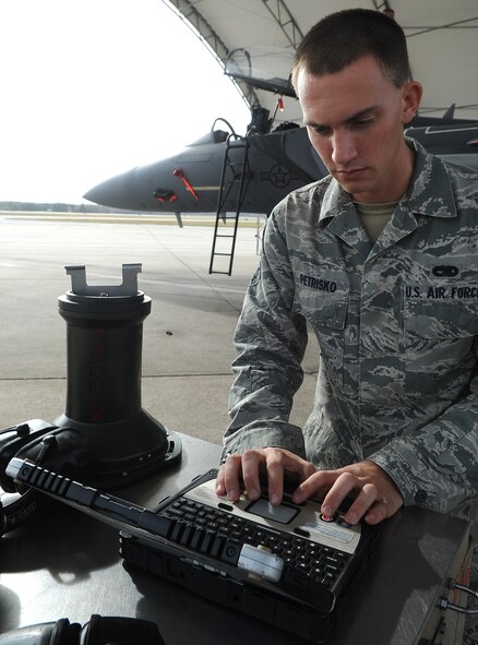 Senior Airman Michael Petrisko, 4th Aircraft Maintenance Squadron avionics journeyman, reviews a technical order prior to inspecting a targeting pod on an F-15E Strike Eagle at Seymour Johnson Air Force Base, N.C., Dec. 6, 2011. The pod is used to accurately fire munitions on a target.  Petrisko hails from Richmond, Ohio. (U.S. Air Force photo by Senior Airman Gino Reyes)