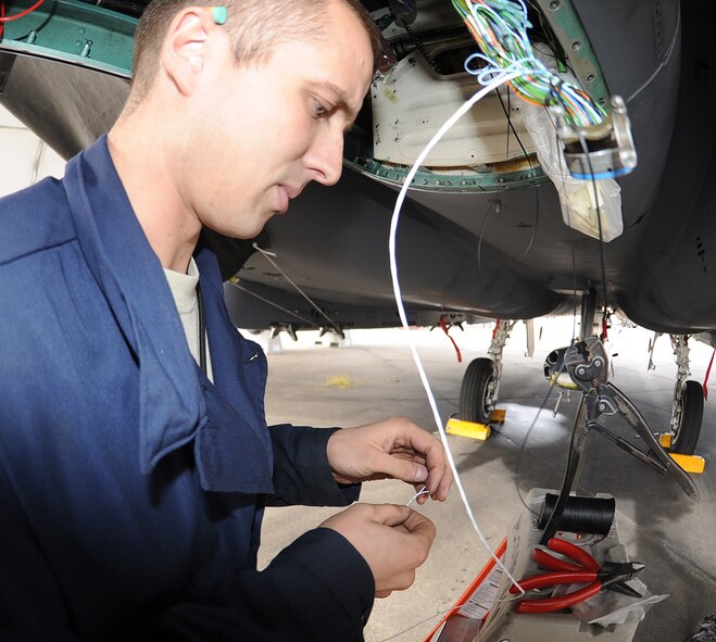 Staff Sgt. Nathan Thompson, 4th Aircraft Maintenance Squadron electrical and environmental (E&E), craftsman repairs wires on an F-15E Strike Eagle at Seymour Johnson Air Force Base, N.C., Dec. 6, 2011. E&E Airmen are responsible for servicing all electrical wires on aircraft and performing regular maintenance to ensure they are in proper working order. Thompson hails from Grayling, Mich. (U.S. Air Force photo by Senior Airman Gino Reyes)