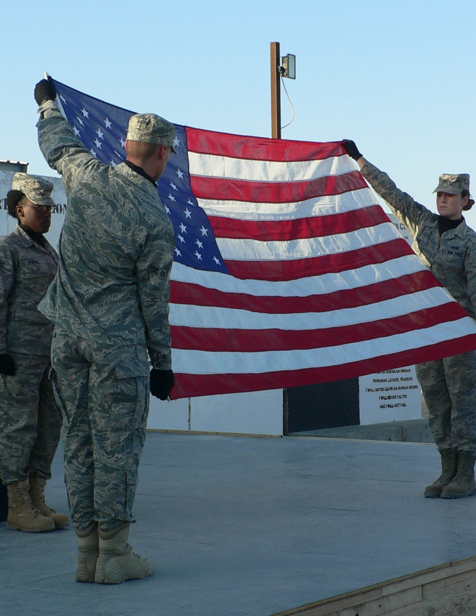 Members of the 405th Air Expeditionary Group honor guard fold the flag during a Pearl Harbor Remembrance Ceremony Dec. 7, 2011, at an air base in Southwest Asia. The Airman's Council, a private organization for junior enlisted members, hosted the event to honor the 70th Anniversary of the surprise aerial attack Dec. 7, 1941, on the U.S. naval base at Pearl Harbor, Hawaii, by the Japanese.   The event precipitated U.S. entry into World War II. Airman 1st Class Nicole Karbowski, the club president, and Senior Airman Savier Rodriguez, the club vice president, organized the event at the deployed unit. (U.S. Air Force photo/Lt. Col. Terrance Sieben)