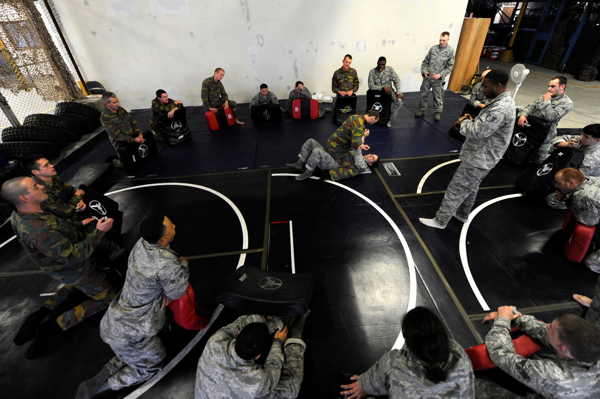 Airmen from the 86th Security Forces and members of the Belgium Army practice modified combative techniques during the flyaway security team training session provided by the 435th Air Ground Operations Wing Dec. 07, 2011, Ramstein Air Base, Germany.  The F.A.S.T specialize in military teams that are in support of contingencies, theater security operation events, humanitarian and civic assistance projects, AEF deployments, and military operations other than war. (U.S. Air Force photo by Staff Sgt. Chris Willis)