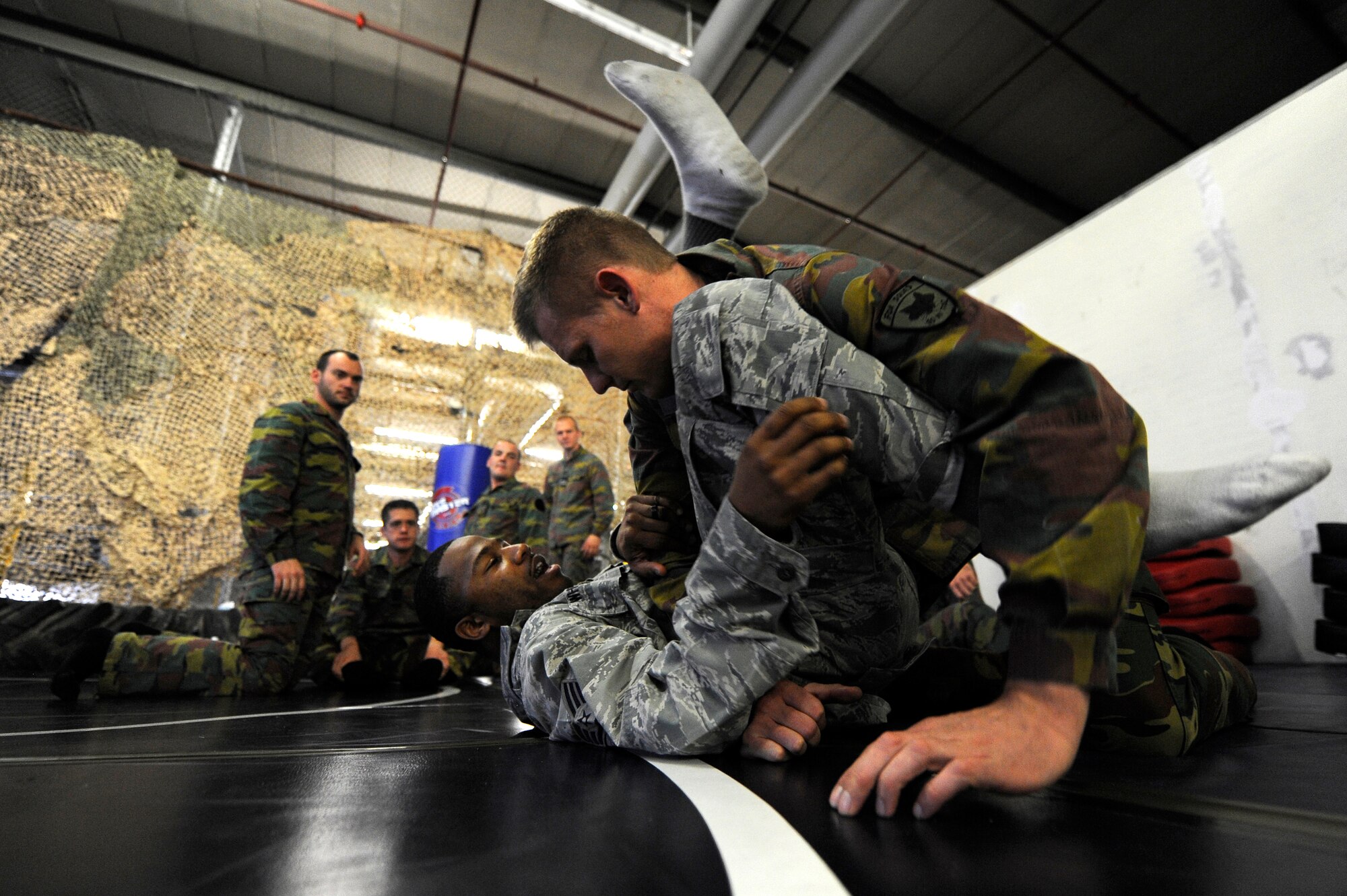 Air Force Staff Sgt. Christopher Whiting, 435th Security Forces Squadron Creek Defender instructor, demonstrates modified army combative technique to Belgian Army Sgt. Dennis Berkmans during a flyaway security team practice session on Dec. 07, 2011, Ramstein Air Base, Germany.  As part of the 435th wing's Contingency Response Group, the 435th SFS contributes to the group's "open the base" mission, as well as expeditionary combat support training through the USAFE Security Forces Regional Training Center's Creek Defender course. (U.S. Air Force photo by Staff Sgt. Chris Willis)