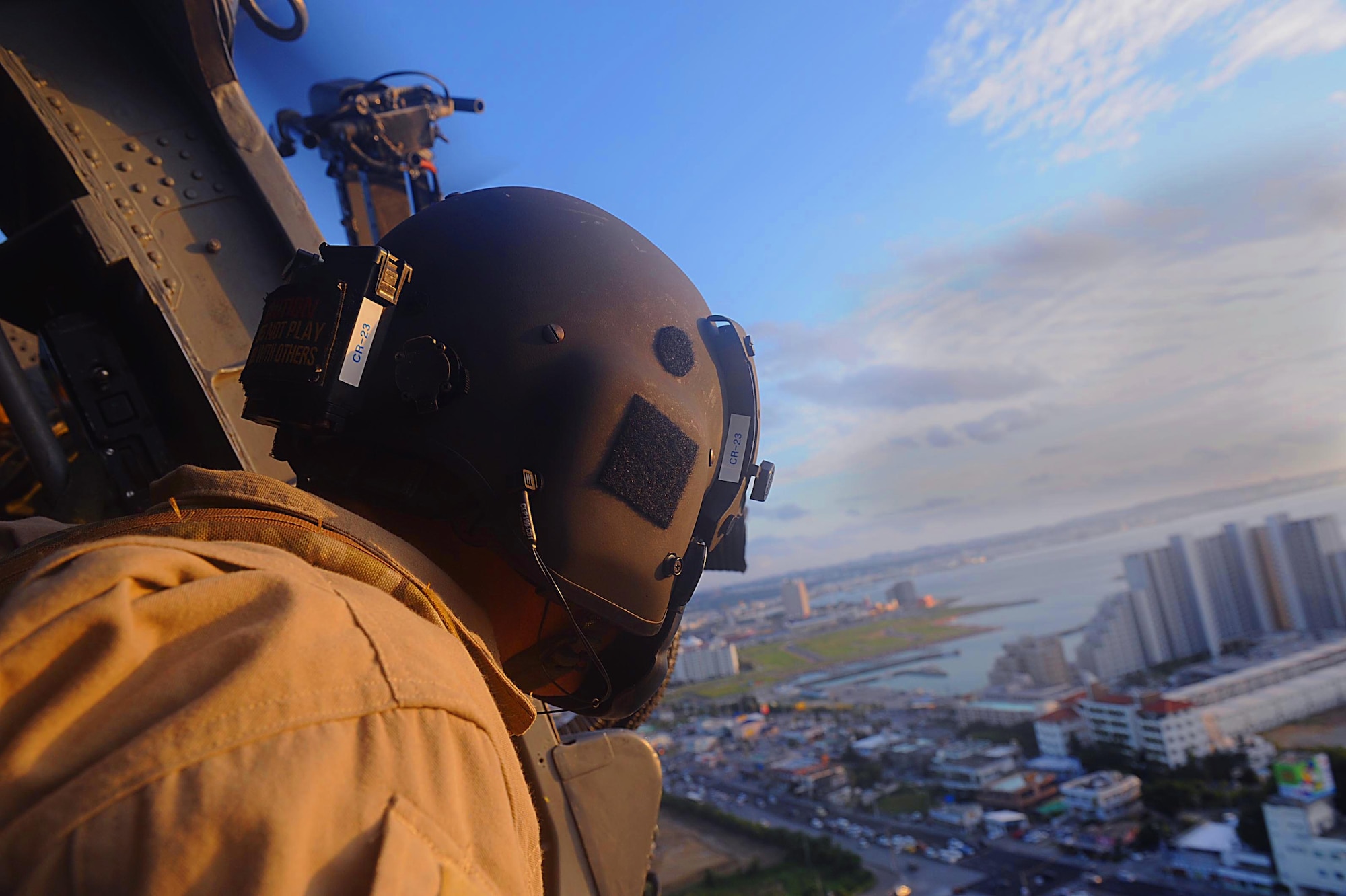 U.S. Air Force Tech. Sgt. Scott Lagerveld, 33rd Rescue Squadron A-Flight chief, looks out the door of a U.S. Air Force HH-60G Pave Hawk helicopter to get a glimpse of Okinawa, Japan, Dec. 7, 2011. The crew was performing a perimeter sweep of Kadena Air Base. (U.S. Air Force photo by Airman 1st Class Brooke P. Beers/Released)