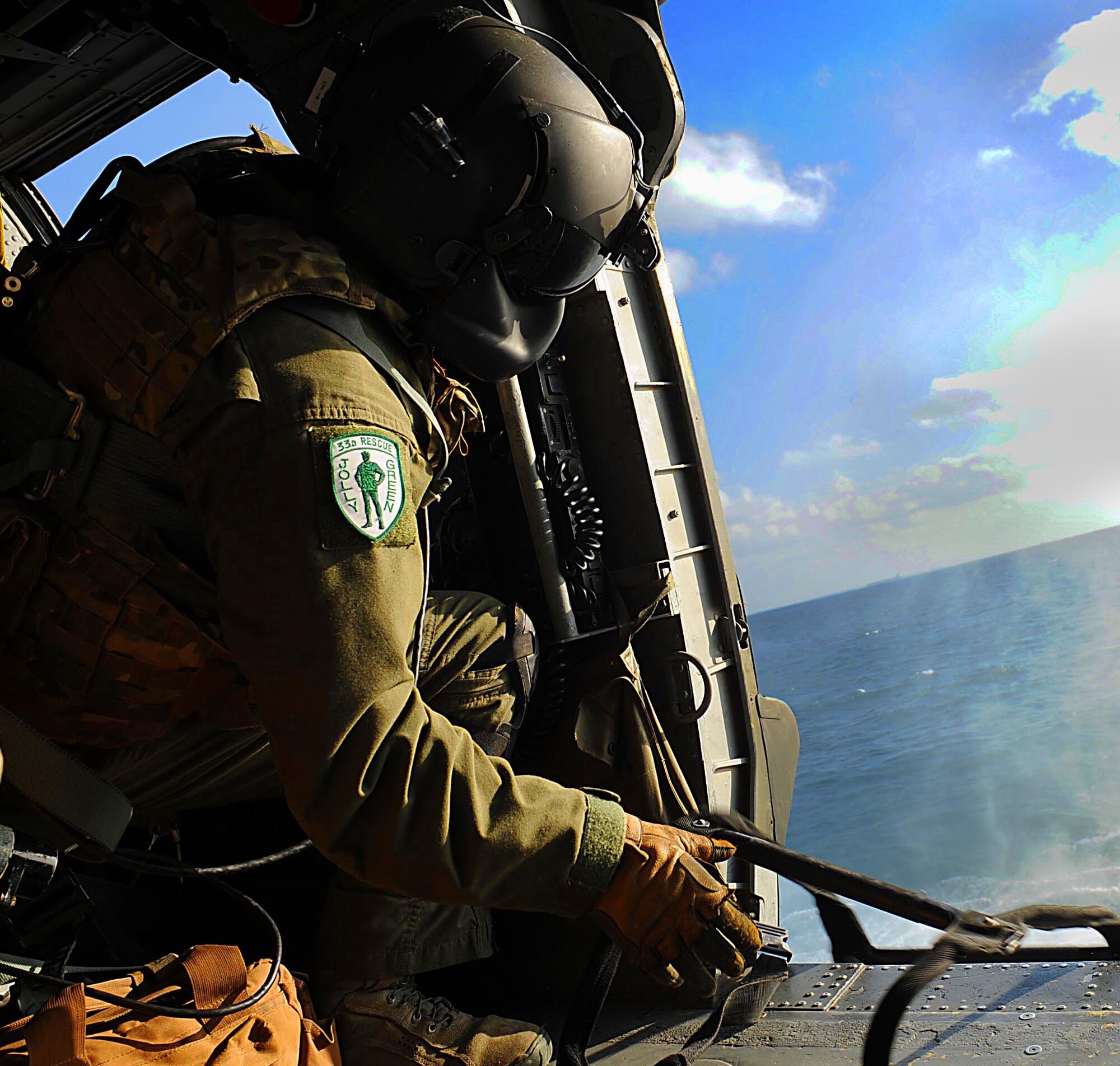 U.S. Air Force Staff Sgt. Dane Hatley, 33rd Rescue Squadron flight engineer, lowers a rope ladder into the ocean from a U.S. Air Force HH-60G Pave Hawk helicopter in Okinawa, Japan, Dec. 7, 2011. Hatley was performing his day-water training. (U.S. Air Force photo by Airman 1st Class Brooke P. Beers/Released)