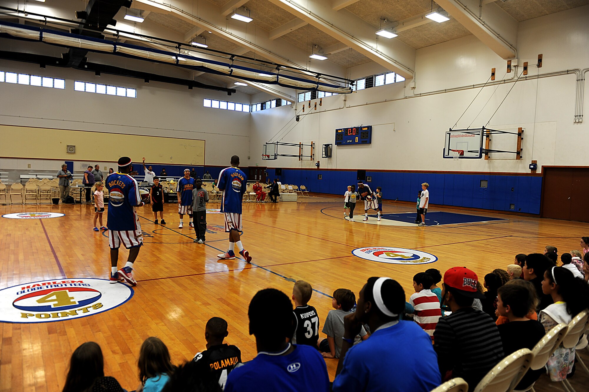 The Harlem Globetrotters perform tricks for children during their Magic Circle routine at the Risner Fitness Center on Kadena Air Base, Japan, Dec. 6, 2011. The Harlem Globetrotters are an exhibition team that performs for audiences worldwide. (U.S. Air Force photo by Airman 1st Class Justin Veazie/Released)