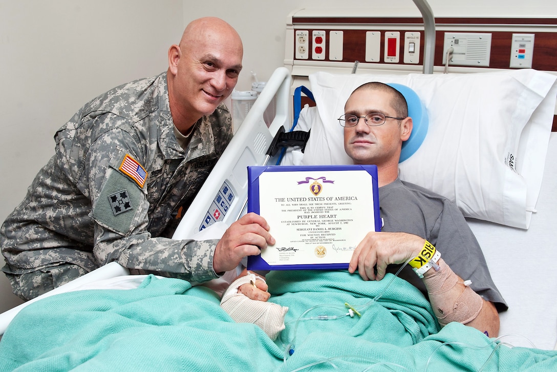 Army Chief of Staff Gen. Raymond T. Odierno presents a Purple Heart to Sgt. Daniel Burgess during a visit to San Antonio Military Medical Center, Dec. 5, 2011. Burgess was assigned to the 350th Tactical Psychological Operations Company.