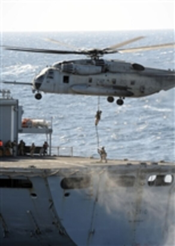 Marines from the Force Reconnaissance Platoon for the 24th Marine Expeditionary Unit fast rope out of an CH-53 Super Stallion assigned to Marine Medium Tilt Rotor Squadron 261 onto the Military Sealift Command fast combat support ship USNS Arctic (T-AOE 8) during a visit, board, search and seizure exercise aboard the amphibious transport dock ship USS New York (LPD 21) in the Atlantic Ocean on Dec. 4, 2011.  The New York is underway participating in a composite training unit exercise.  