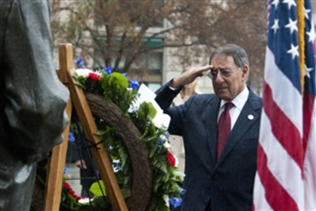 Secretary of Defense Leon E. Panetta salutes as taps is played during a wreath laying ceremony at the Navy Memorial in Washington, D.C., on December 7, 2011.  Panetta remembered the 70th anniversary of the Pearl Harbor attack and spoke with survivors and witnesses.  