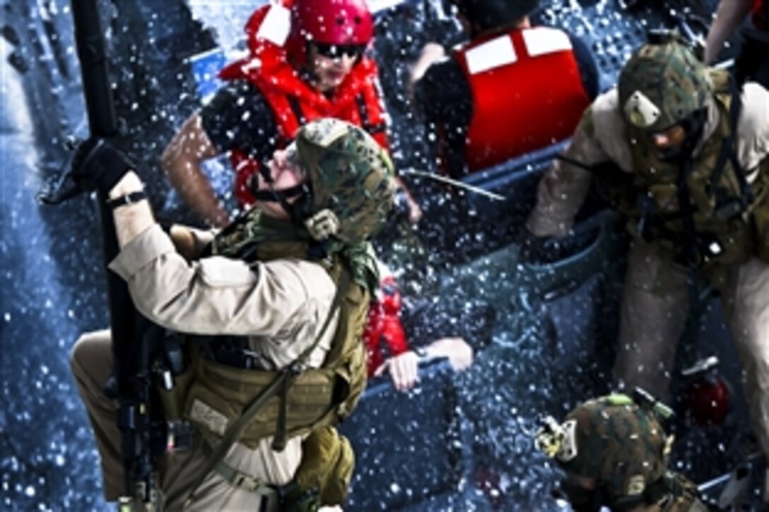 U.S. Marines and sailors climb up the side of the USNS Arctic while conducting a simulated expanded, visit, board, search and seizure mission as part of a composite training exercise while under way in the Atlantic Ocean, Dec. 7, 2011. The troops are assigned to the 24th Marine Expeditionary Unit's Force Reconnaissance Platoon.