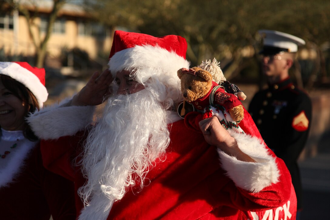 Santa Claus salutes a long formation of students with the Marine Corps Communication-Electronics School as they run to drop off Toys for Tots donations in front of the Combat Center’s command deck Dec. 9, 2011.