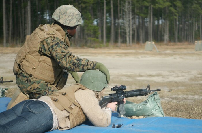 A spouse shoots an M-16 A4 service rifle during Jane Wayne Day with Combat Logistics Regiment 27, 2nd Marine Logistics Group aboard Camp Lejeune, N.C., Dec. 9, 2011. Spouses dawned flacks and Kevlar helmets to lay rounds down range at a target approximately 50 meters away. (U.S. Marine Corps photo by. Pfc. Franklin E. Mercado)