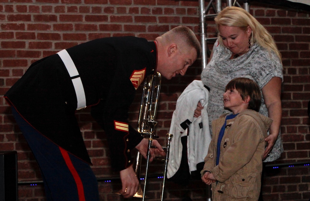 Staff Sgt. Brian C. McCartney, a trombone instrumentalist for the 2nd Marine Aircraft Wing Band, greets a young friend at the conclusion of the annual 2nd MAW Band Christmas Concert at Marine Corps Air Station Cherry Point, N.C., Dec. 9, 2011. A record crowd of more than 2,000 guests packed the station theater for the event. “It’s about all of these people, it’s not about us,” said McCartney.