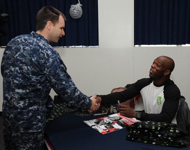 Petty Officer 1st Class Glenn Warren, C-37B Crew Chief, VR-1 Fleet Logistics Support Squadron, Joint Base Andrews, Md., meets sports bike free-style rider Jason Britton Dec. 8 at the USO pizza party on Joint Base Andrews, Md. Britton signed autographs and thanked came to thank servicemembers for their service. (U.S. Air Force photo by Staff Sgt. Christopher Ruano)