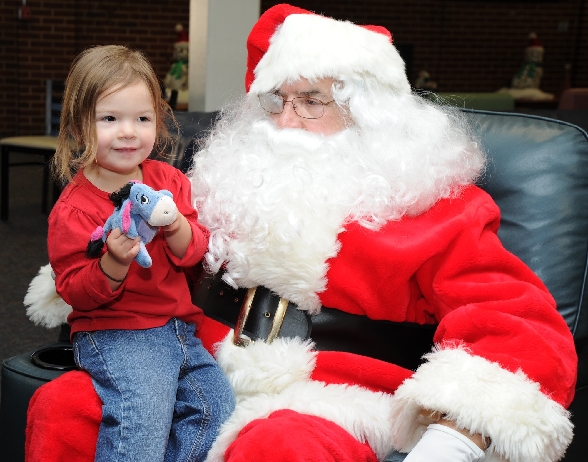 Autumn Barrett, daughter of Airmen 1st Class James Barrett, 11 Wing contract specialist, sits on Santa’s lap Dec. 8 at the USO pizza party on Joint Base Andrews, Md. Santa was present to bring holiday cheer to the troops. (U.S. Air Force photo by Staff Sgt. Christopher Ruano) 