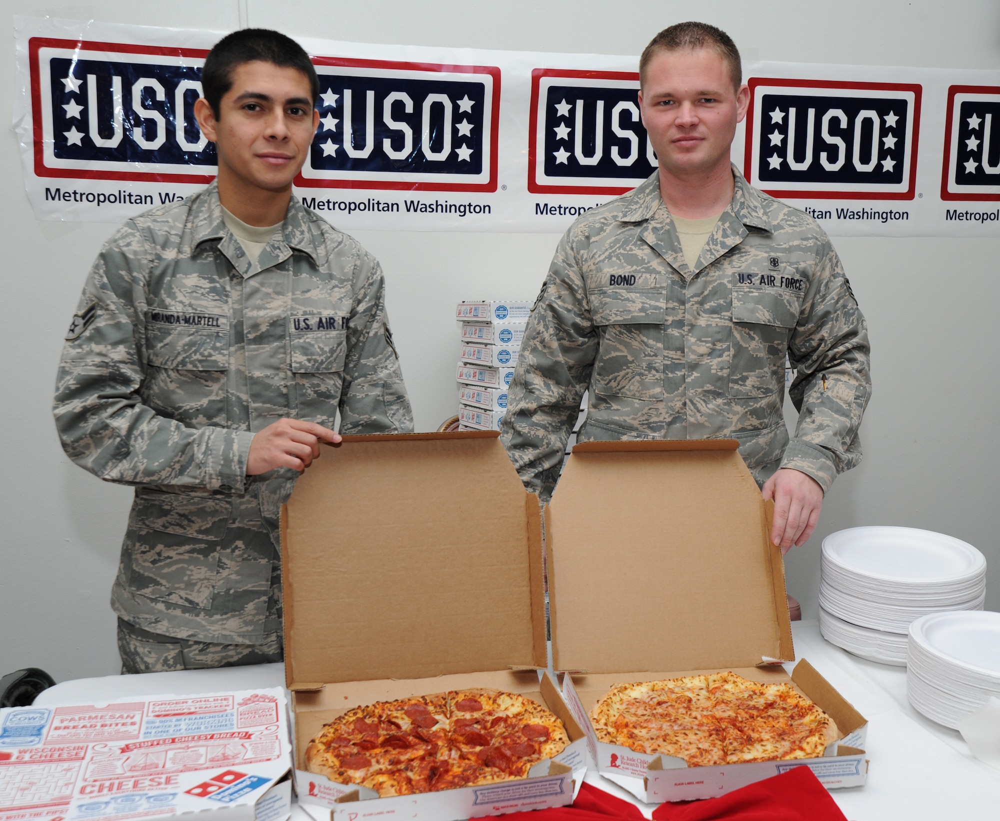 Airmen 1st Class Andres Miranda-Martell and Senior Airmen Robert Bond, 779th Medical Group radiology technologists, volunteer to serve pizza Dec. 8 at the USO pizza party on Joint Base Andrews, Md. More than 300 Airmen, Sailors and Marines from the local area units came to enjoy the free pizza, music, games and gifts. (U.S. Air Force photo by Staff Sgt. Christopher Ruano)