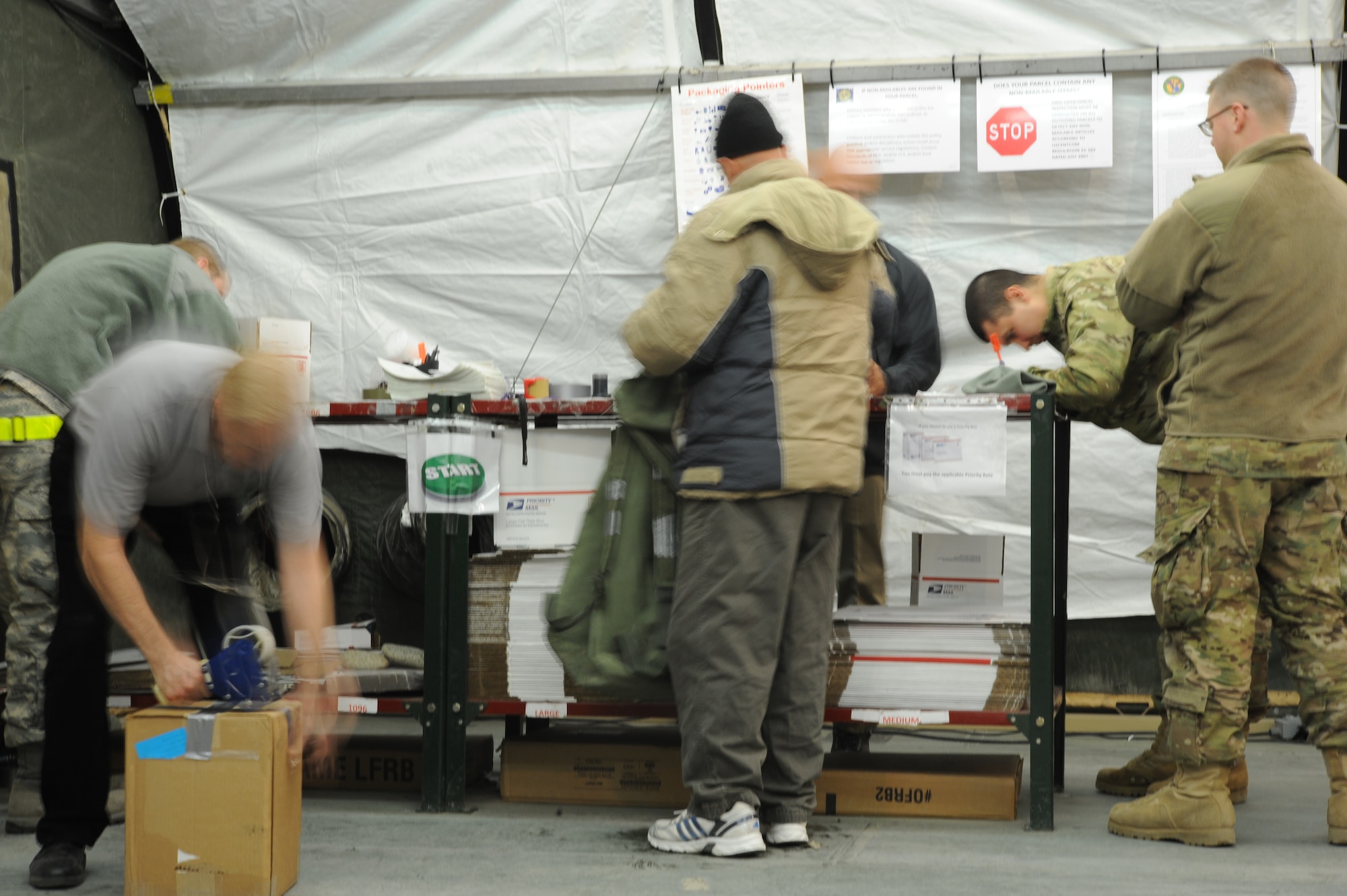 People move busily around the post office securing packages and filling out customs forms at the Transit Center at Manas, Kyrgyzstan, Dec. 9, 2011. The post office here sends out an average of 800 pieces of mail daily. (U.S. Air Force Photo/Tech. Sgt. Hank Hoegen)