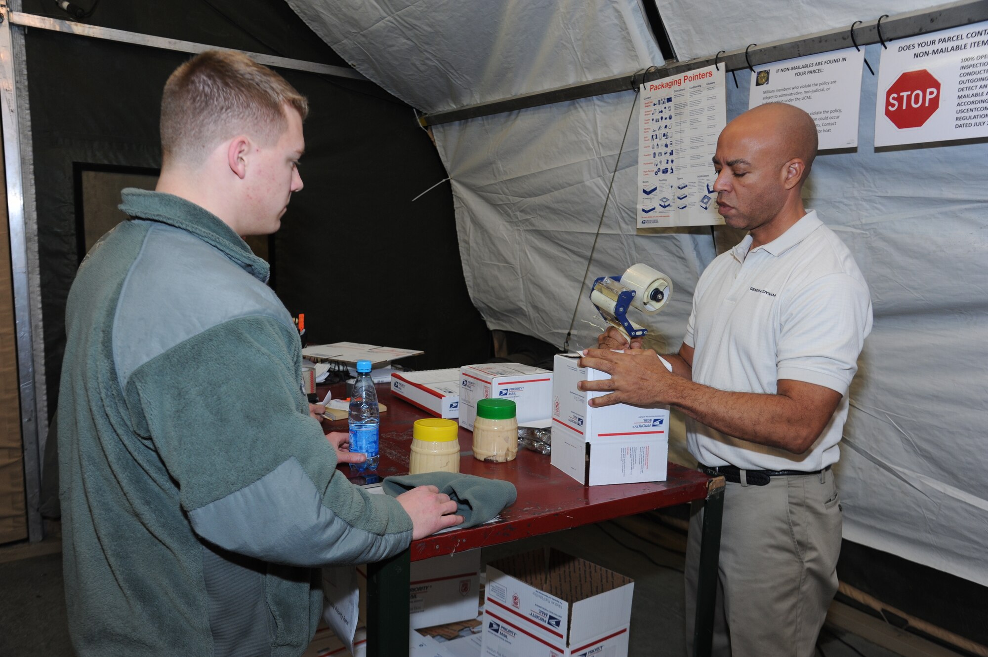 Post master Owen Smith helps Senior Airman Jackson Zimmerman package items to be mailed from the post office at the Transit Center at Manas, Kyrgyzstan, Dec. 7.  The post office here sends out an average of 800 pieces of mail daily. Zimmerman, 728th Aircraft Maintenance Squadron crew chief, is deployed from the 107th Maintenance Group, Niagara Falls, N.Y. (U.S. Air Force Photo/Tech. Sgt. Hank Hoegen)