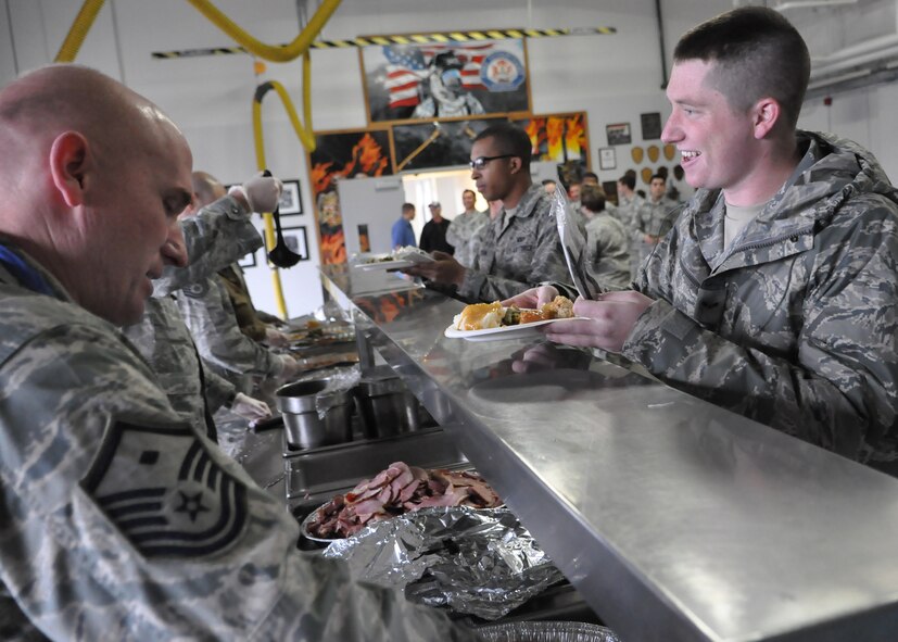 First sergeants serve lunch to an Airman Dec. 9, 2011, during the fourth annual unaccompanied Airmen holiday feast at Joint Base Lewis-McChord, Wash. (U.S. Air Force photo/Airman 1st Class Leah Young)