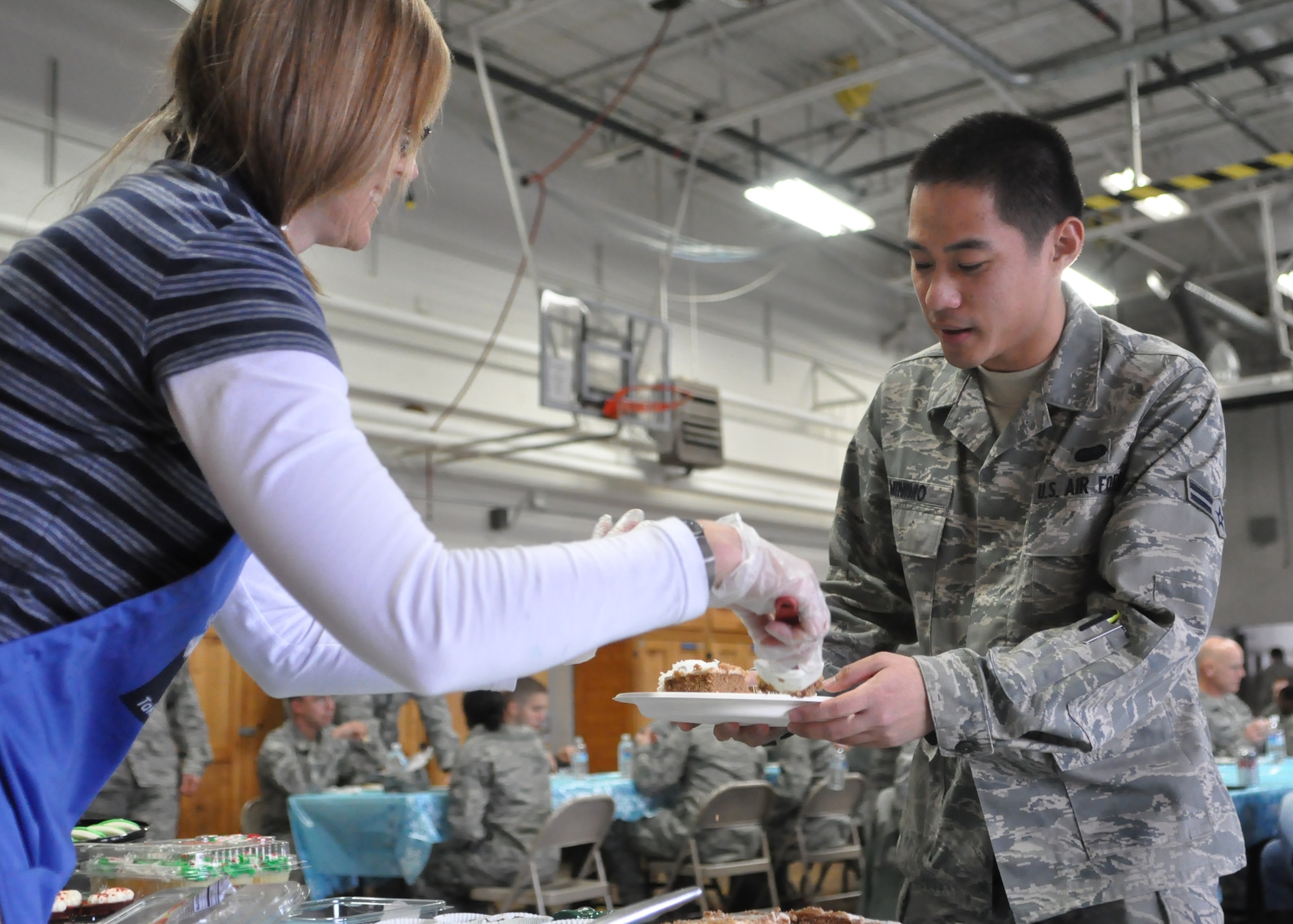 Airman 1st Class Justin Raymond Minimo, 627th Communications Squadron, is served dessert Dec. 9, 2011, during the fourth annual Unaccompanied Airmen Holiday Feast at Joint Base Lewis-McChord, Wash. (U.S. Air Force photo/Airman 1st Class Leah Young)