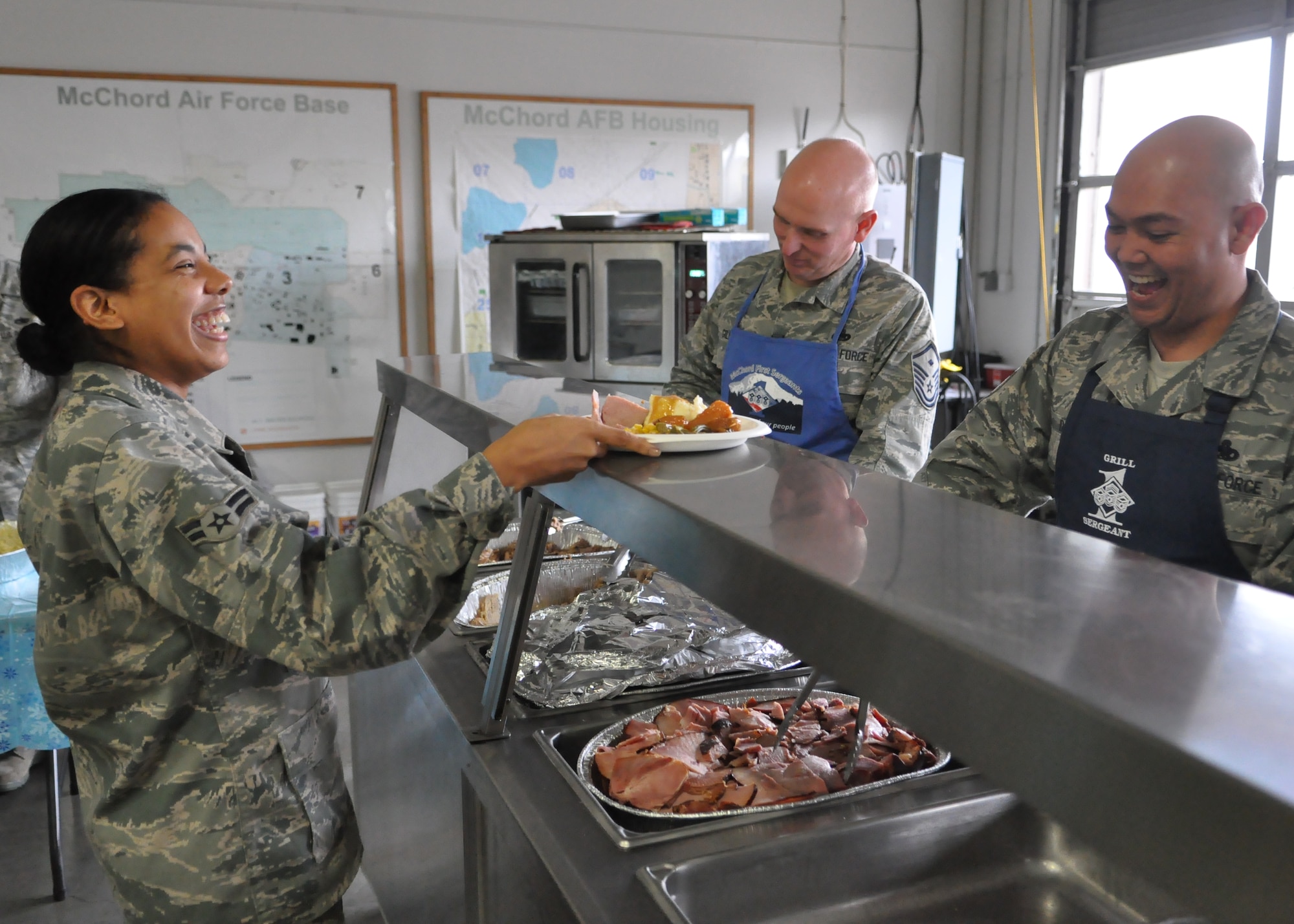 First sergeants serve lunch to an Airman Dec. 9, 2011, during the fourth annual Unaccompanied Airmen Holiday Feast at Joint Base Lewis-McChord, Wash. (U.S. Air Force photo/Airman 1st Class Leah Young)