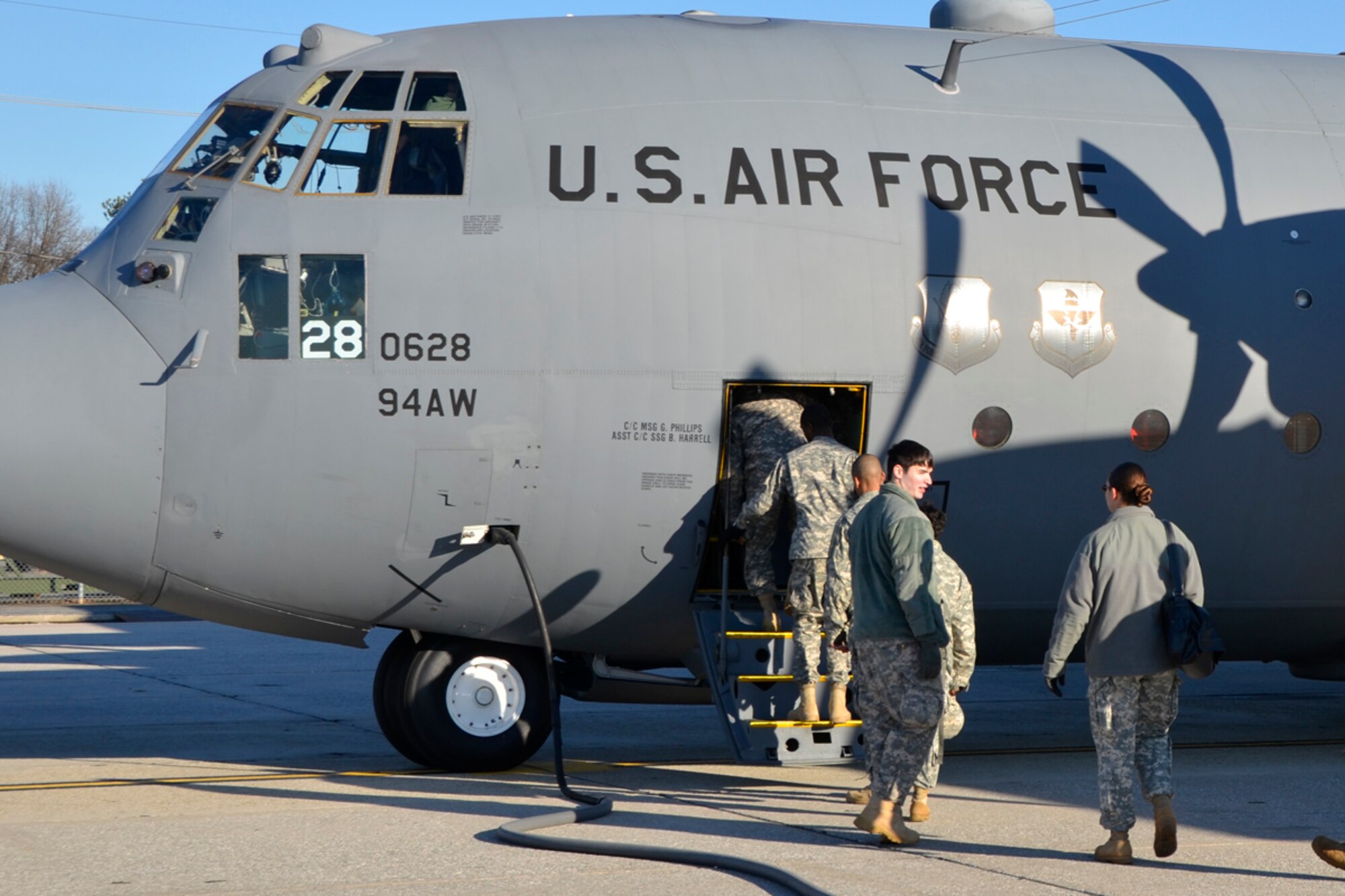 Members of the Army 382nd Combat Camera, East Point, Ga., board a Dobbins Air Reserve Base C-130 in route to Fort Bragg, N.C. in support of Operation Toy Drop. The unit will document approximately 4000 paratroopers from the U.S. Army Civil Affairs and Psychological Operations Command, 18th Airborne Corps and visiting paratroopers from 11 countries as they parachute and deliver new, unwrapped toys to be distributed to local children's homes and social service agencies. (U.S. Air Force photo/Master Sgt. James Branch)