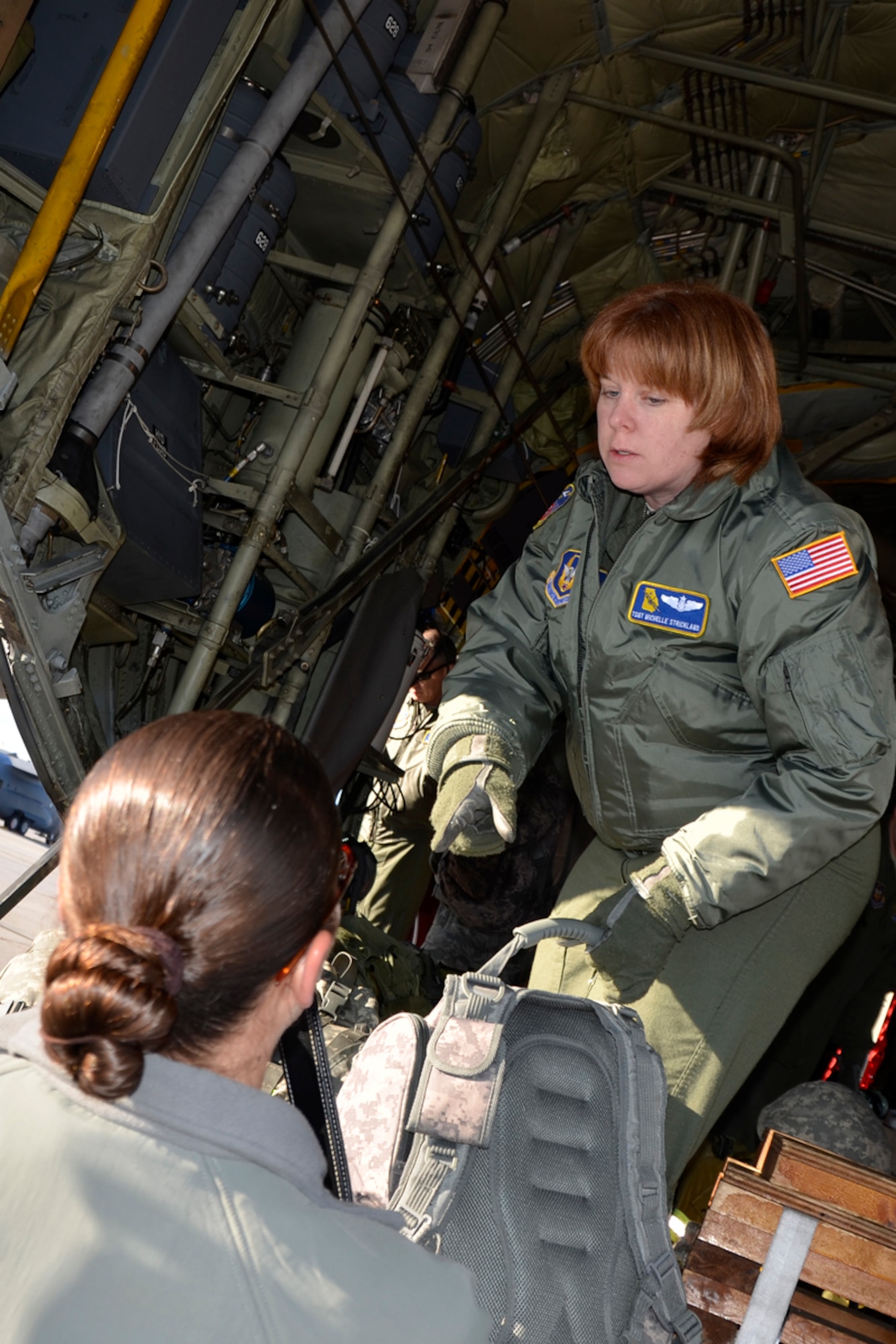 Tech. Sgt. Darlene M. Strickland, 700th Airlift Squadron loadmaster, assists members of the Army 382nd Combat Camera, East Point, Ga., with loading their gear before taking off to Fort Bragg, N.C. in support of Operation Toy Drop. Approximately 4000 paratroopers from the U.S. Army Civil Affairs and Psychological Operations Command, 18th Airborne Corps and visiting paratroopers from 11 countries will parachute from Dobbins’ and other aircraft and deliver new, unwrapped toys to be distributed to local children's homes and social service agencies. (U.S. Air Force photo/Master Sgt. James Branch)