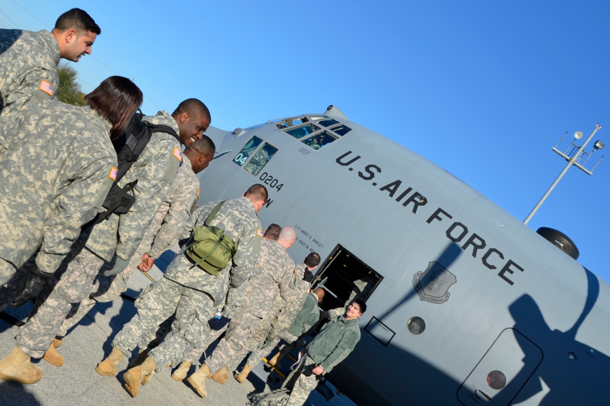 Members of the Army 382nd Combat Camera, East Point, Ga., board a Dobbins Air Reserve Base C-130 in route to Fort Bragg, N.C. in support of Operation Toy Drop. The unit will document approximately 4000 paratroopers from the U.S. Army Civil Affairs and Psychological Operations Command, 18th Airborne Corps and visiting paratroopers from 11 countries as they parachute and deliver new, unwrapped toys to be distributed to local children's homes and social service agencies. (U.S. Air Force photo/Master Sgt. James Branch)