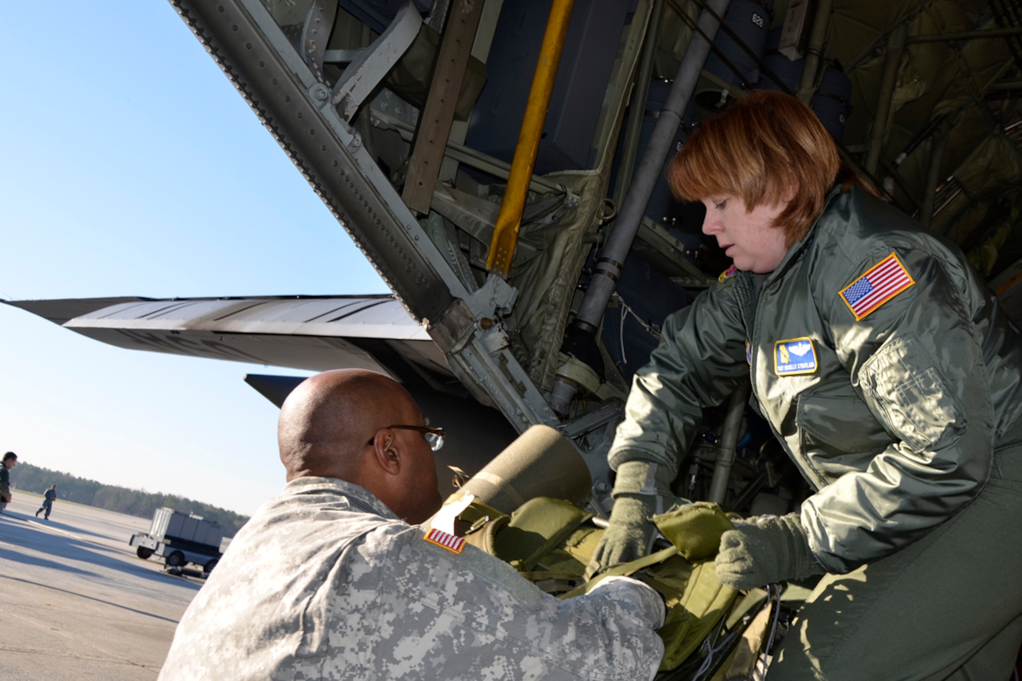 Tech. Sgt. Darlene M. Strickland, 700th Airlift Squadron loadmaster, assists members of the Army 382nd Combat Camera, East Point, Ga., with loading their gear before taking off to Fort Bragg, N.C. in support of Operation Toy Drop. Approximately 4000 paratroopers from the U.S. Army Civil Affairs and Psychological Operations Command, 18th Airborne Corps and visiting paratroopers from 11 countries will parachute from Dobbins’ and other aircraft and deliver new, unwrapped toys to be distributed to local children's homes and social service agencies. (U.S. Air Force photo/Master Sgt. James Branch)