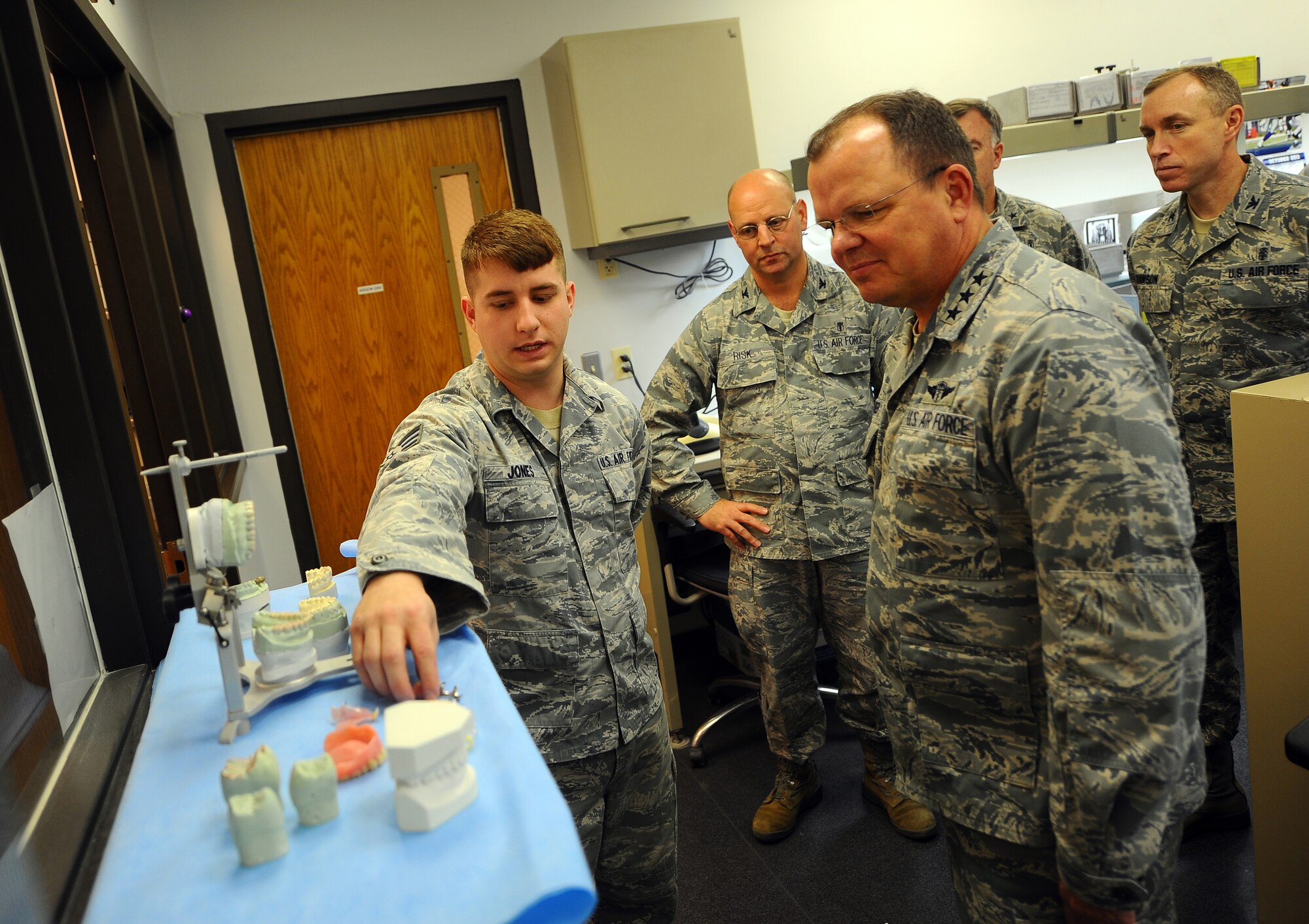 U.S. Air Force Senior Airman David Jones gives a tour of the dental lab to U.S. Air Force Surgeon General Lt. Gen. C. Bruce Green, while on his tour of Ehrling Berguist Clinic, Offutt Air Force Base, Neb., Dec. 1. The surgeon general had an opportunity to meet with Airmen of the 55th Wing Medical Group during his tour of their operations. (U.S. Air Force photo by Josh Plueger/Released).