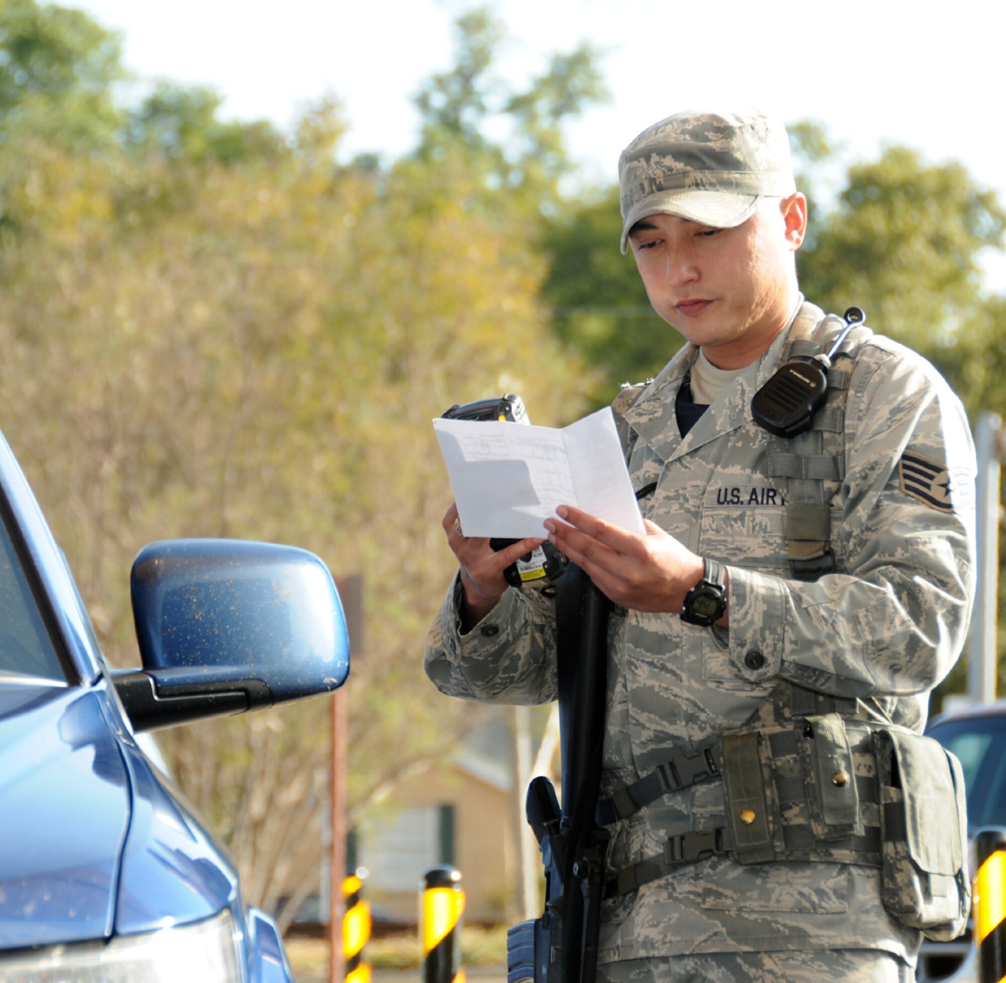 Staff Sgt. David Reimer, 81st Security Force Squadron augmentee from the 81st Dental Squadron, checks identification cards as visitors enter the White Avenue Gate at Keesler Air Force Base, Miss., Nov. 3, 2011.  Augmentees are being used to support Security Forces manning.  (U.S. Air Force photo by Kemberly Groue)