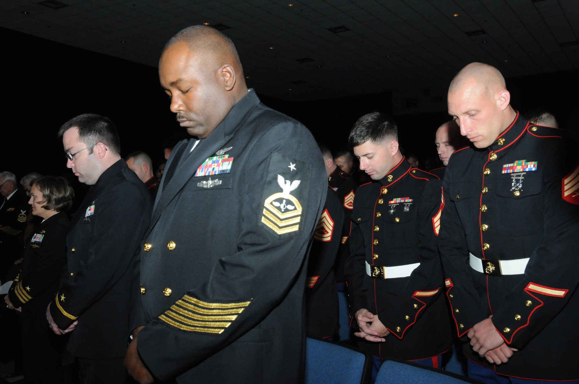 Ensign Kenneth Lutza, Center for Naval Aviation Technical Training Unit; Senior Chief James Green, CNATTU; Staff Sgt. Travis Gore, Marine Detachment; and Sgt. Matthew Petitgout, MARDET, pause for a moment of silence during a Pearl Harbor Remembrance Ceremony at the Welch Theater at Keesler Air Force Base, Miss., Dec. 7, 2011.  Pearl Harbor was attacked on Dec. 7, 1941.  (U.S. Air Force photo by Kemberly Groue)