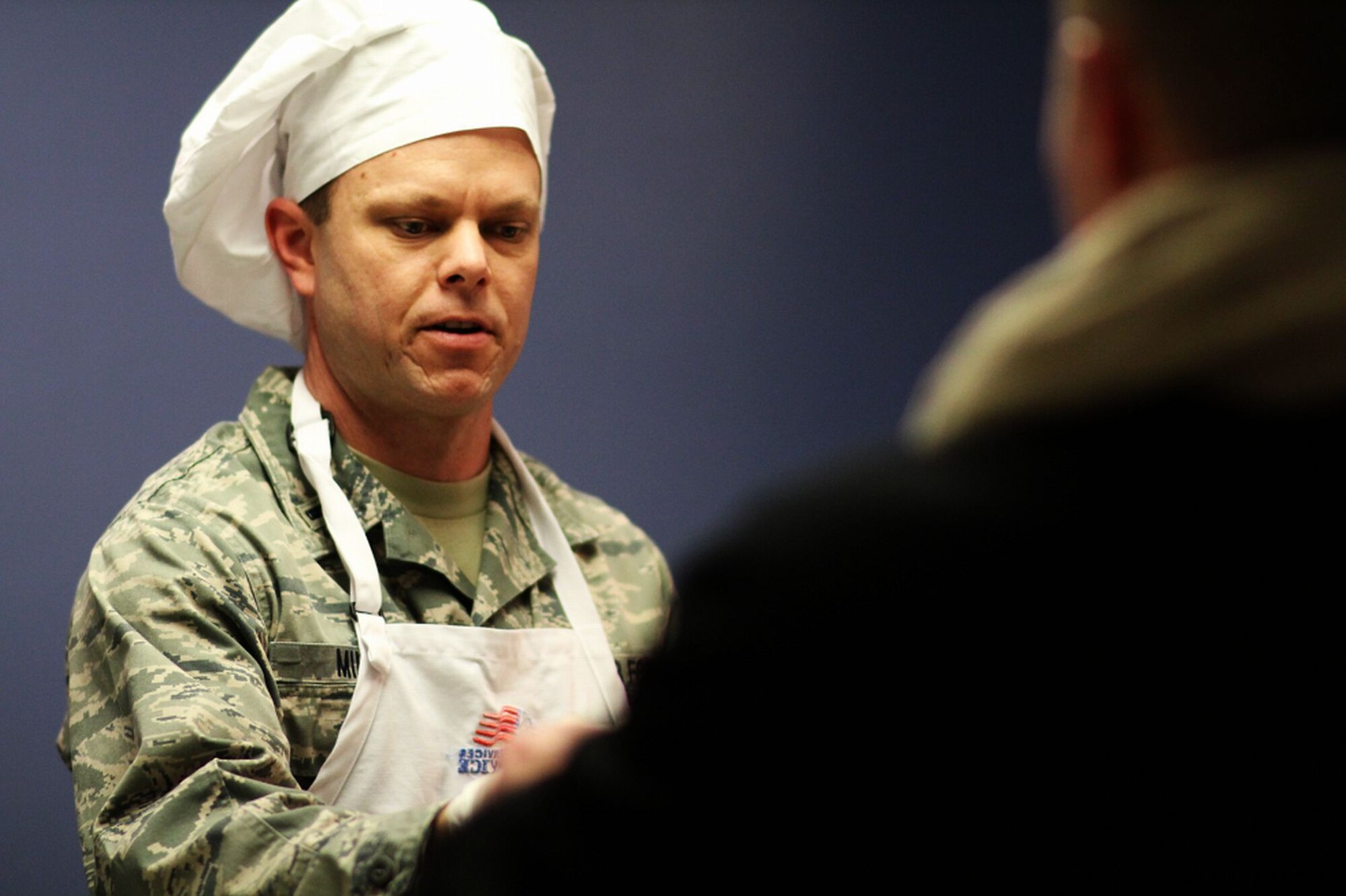 MINOT AIR FORCE BASE, N.D. -- 1st Lt. Jeremy Miller, 5th Force Support Squadron, volunteers his time at the Dining Facility here to serve young enlisted Airmen meals. The officers provide this monthly community service as part of the Minot AFB Company Grade Officers’ Council outreach. (U.S. Air Force photo/ Capt. Jon Arceta)