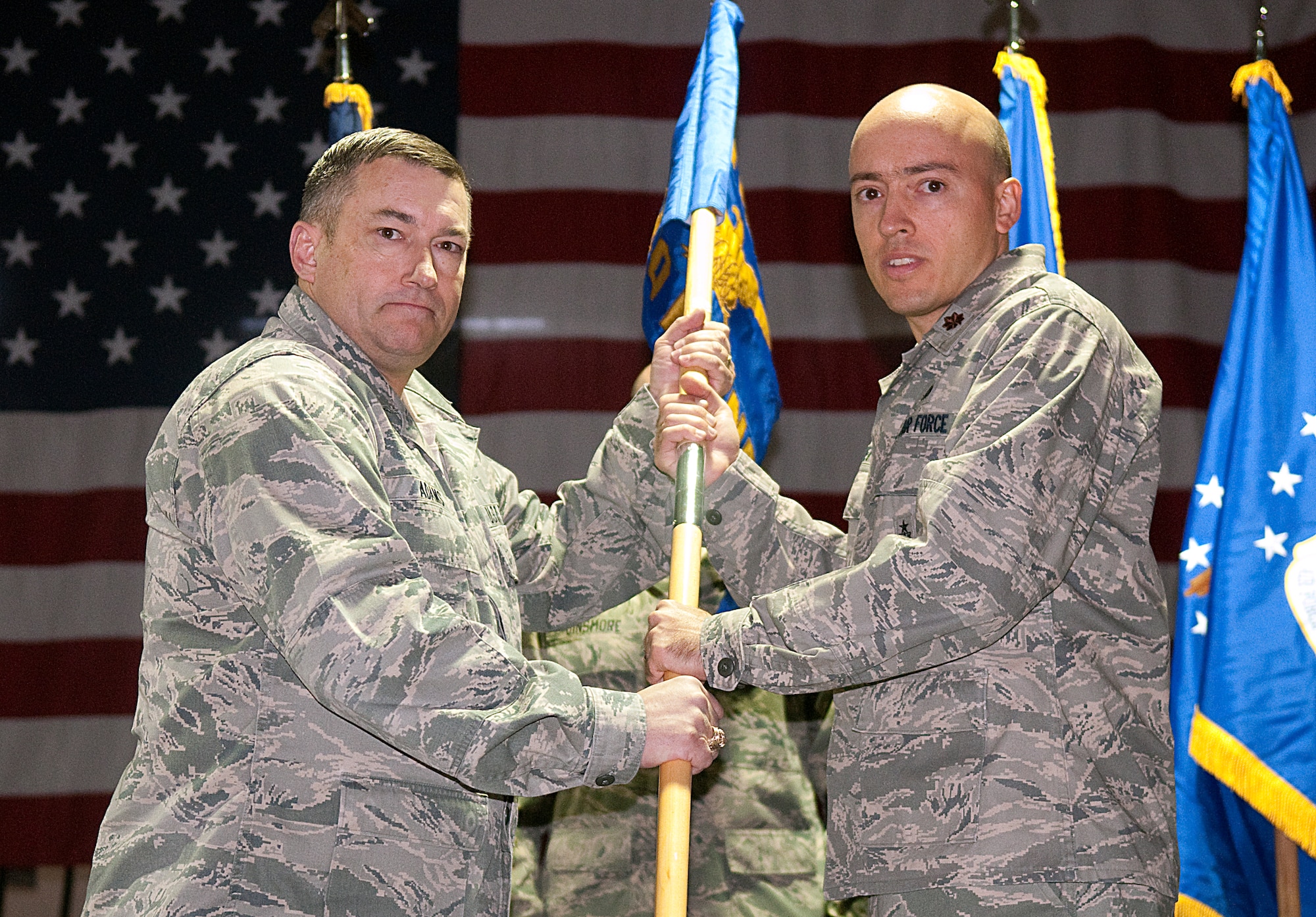 Col. Don Adams, 90th Maintenance Group commander, hands Maj. Jay Moret, 90th Munitions Squadron commander, the 90th MUNS guidon during the activation ceremony Dec. 1 here. (U.S. Air Force photo by R.J. Oriez)