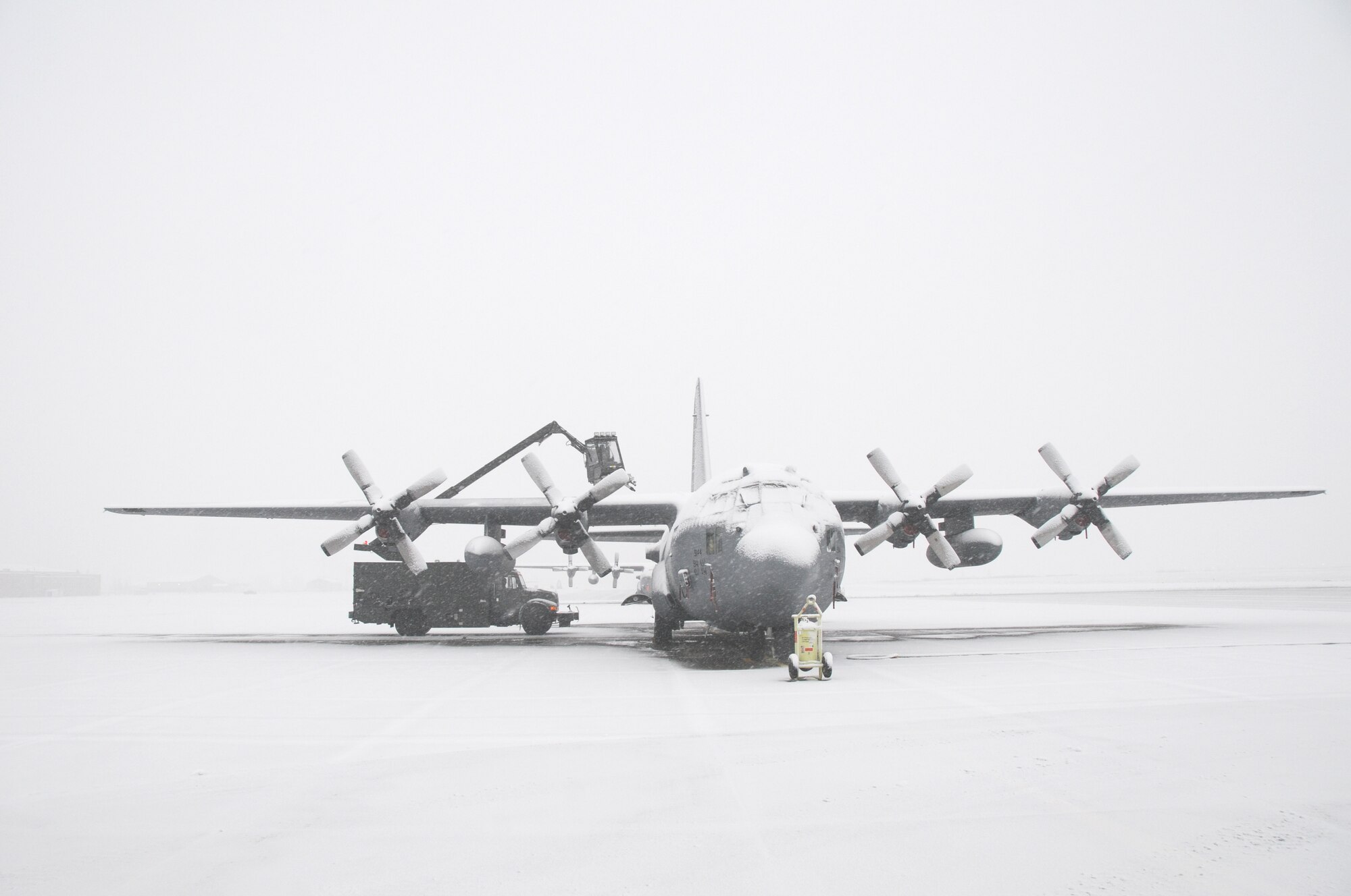 Lake effect snow doesn't stop the members of the 107th and 914th Airlift Wings prep the C-130 aircraft for its mission. Deicing is being done before flight on December 9, 2011. (Air Force Photo/SMSgt Ray Lloyd)