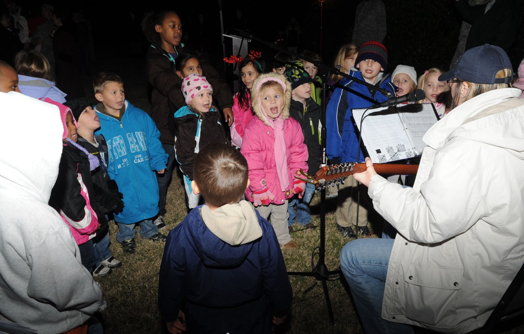 Children sing “Here Comes Santa Claus” during the 44th Annual Christmas tree lighting ceremony at the base chapel on Langley Air Force Base, Va., Dec. 8, 2011. Families gathered during the ceremony on the chapel lawn, sang seasonal carols and waited for a special visit from Santa Claus. (U.S. Air Force Photo by Airman 1st Class Racheal Watson)