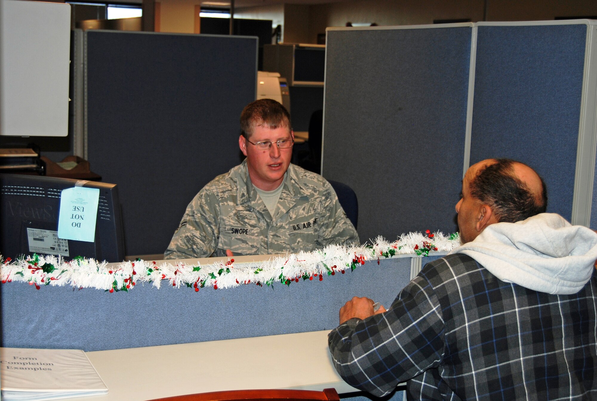 Airman 1st Class Kevin Swope, 21st Comptroller Squadron financial services representative, assists a customer in the financial services office. Since August, military pay has been moved from the Financial Services Center at Ellsworth Air Force Base, S.D., to the base level. The move means customers will see changes to their pay in a more timely manner. (U.S. Air Force photo/Lea Johnson)