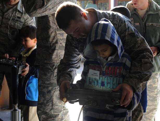 Belel Touma, along with his mentor Senior Airmen Joseph Berglund, control the robots during a base tour of Joint Base Charleston-Air Base Deb. 8. JB Charleston's Airmen Leadership School invited more than 30 third grade students from Memminger Elementary School to tour the base. This tour is part of an on-going community service project to bring awareness to the opportunities the Air Force has to offer future generations. Berglund is a loadmaster from the 17 Airlift Squadron, 437th Airlift Wing. (U.S. Air Force photo/Airman 1st Class Ashlee Galloway)