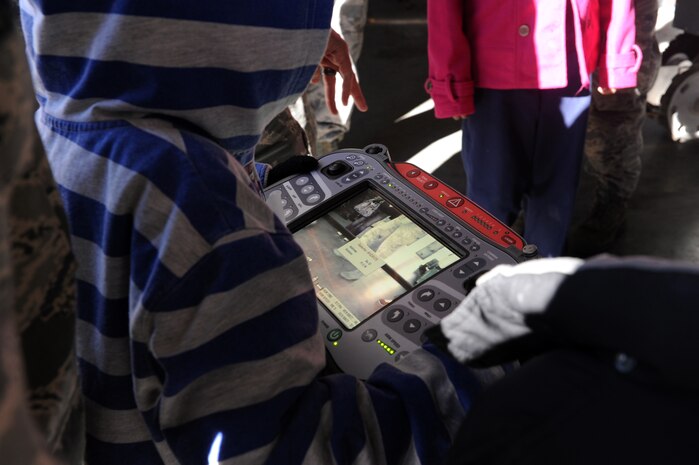 Belel Touma, along with his mentor Senior Airmen Joseph Berglund, control the robots during a base tour of Joint Base Charleston-Air Base Deb. 8. JB Charleston's Airmen Leadership School invited more than 30 third grade students from Memminger Elementary School to tour the base. This tour is part of an on-going community service project to bring awareness to the opportunities the Air Force has to offer future generations. Berglund is a loadmaster from the 17 Airlift Squadron, 437th Airlift Wing. (U.S. Air Force photo/Airman 1st Class Ashlee Galloway)