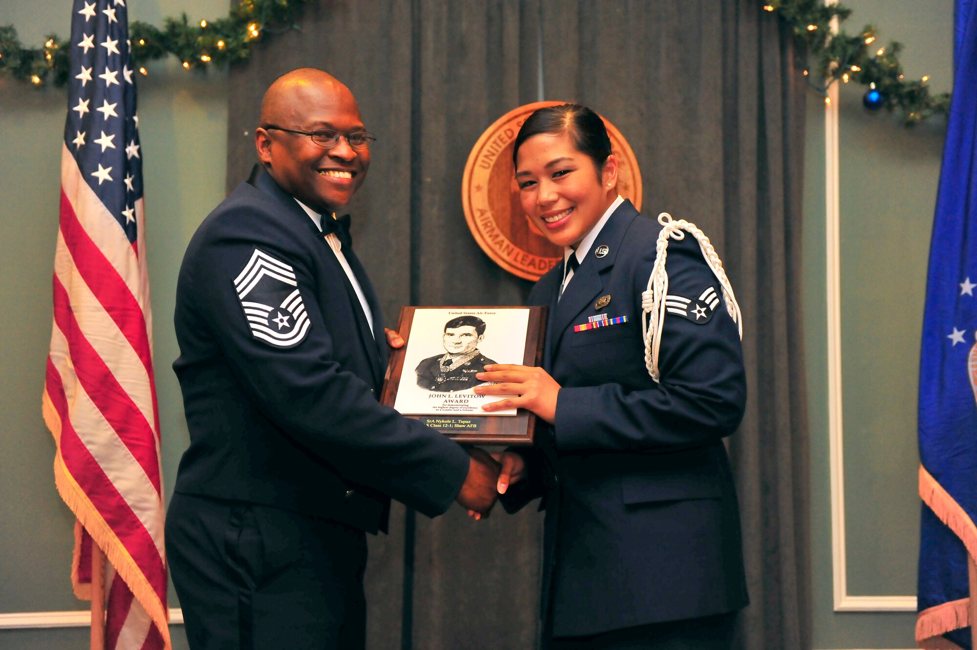 U.S. Air Force Chief Master Sgt. Christopher G. Gooding, 20th Component Maintenance Squadron maintenance superintendent, presents Senior Airman Nykole Tupaz, 3rd Intelligence Squadron cryptologic linguist, with the John Levitow Award at Carolina Skies, Dec. 8, 2011, Shaw Air Force Base, S.C. The John Levitow Award is presented to the top student in each class for achieving excellence in academics, leadership and team work. (U.S. Air Force photo by Airman 1st Class Neil D. Warner)
