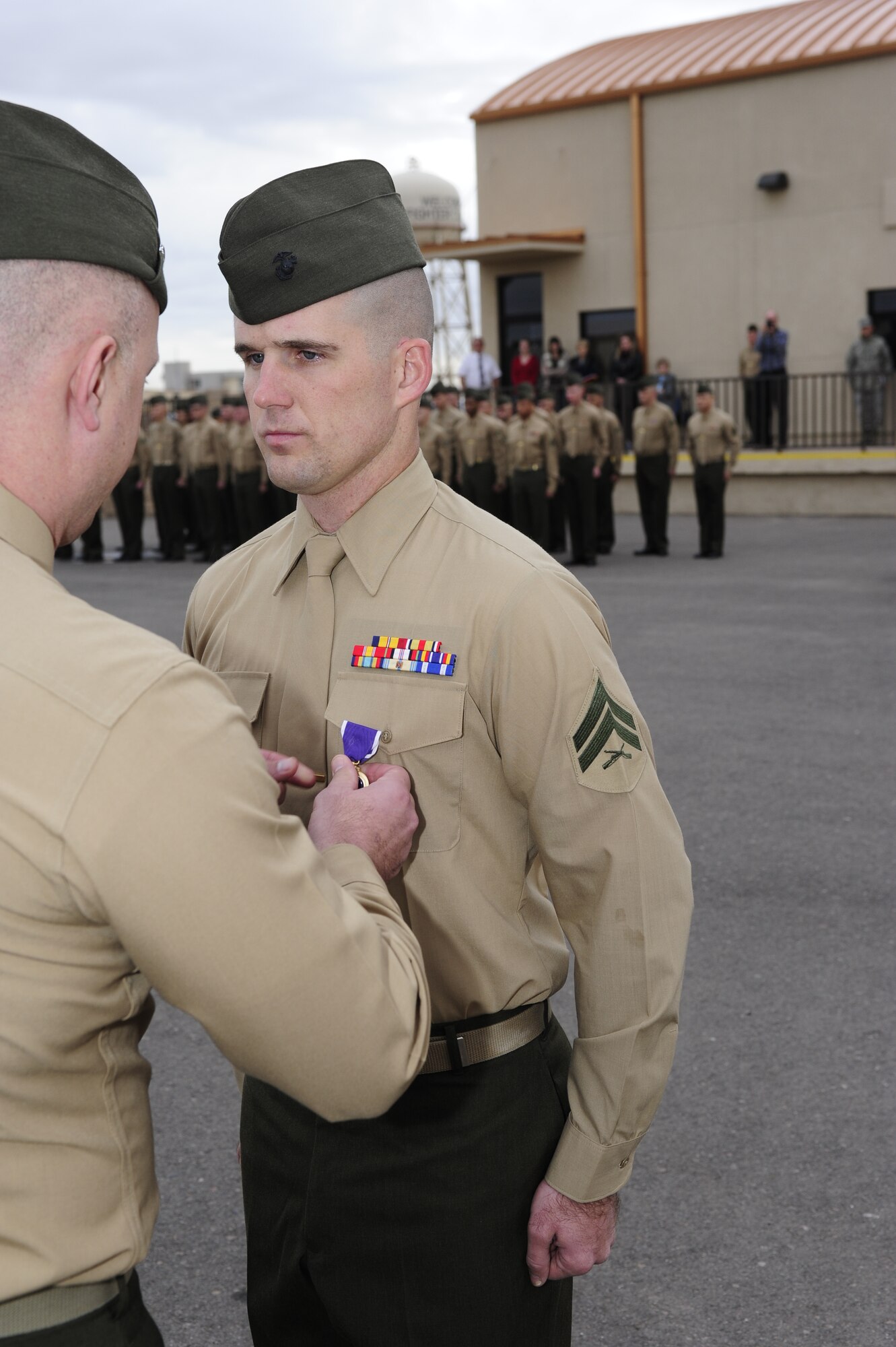 Lt. Col. Sean Riddell, Marine Forces Reserve 6th Engineer Support Battalion commanding officer, presents the Purple Heart to Cpl. Lance Pew, Bulk Fuel Company C bulk fuel specialist, in a ceremony Dec. 3 at Luke Air Force Base. Pew was injured from an improvised explosive device Aug. 31 in Afghanistan.  (U.S. Air Force photo by Staff Sgt. Jason Colbert)