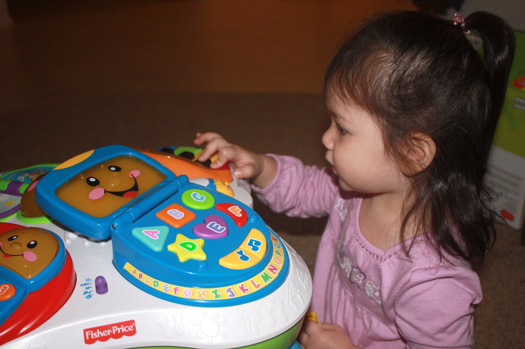 Kallie Willhite, 1, daughter of Staff Sgt. Denise Willhite, 944th Fighter Wing Public Affairs photographer, entertains herself with a toy.  (U.S. Air Force photo by Staff Sgt. Denise Willhite)