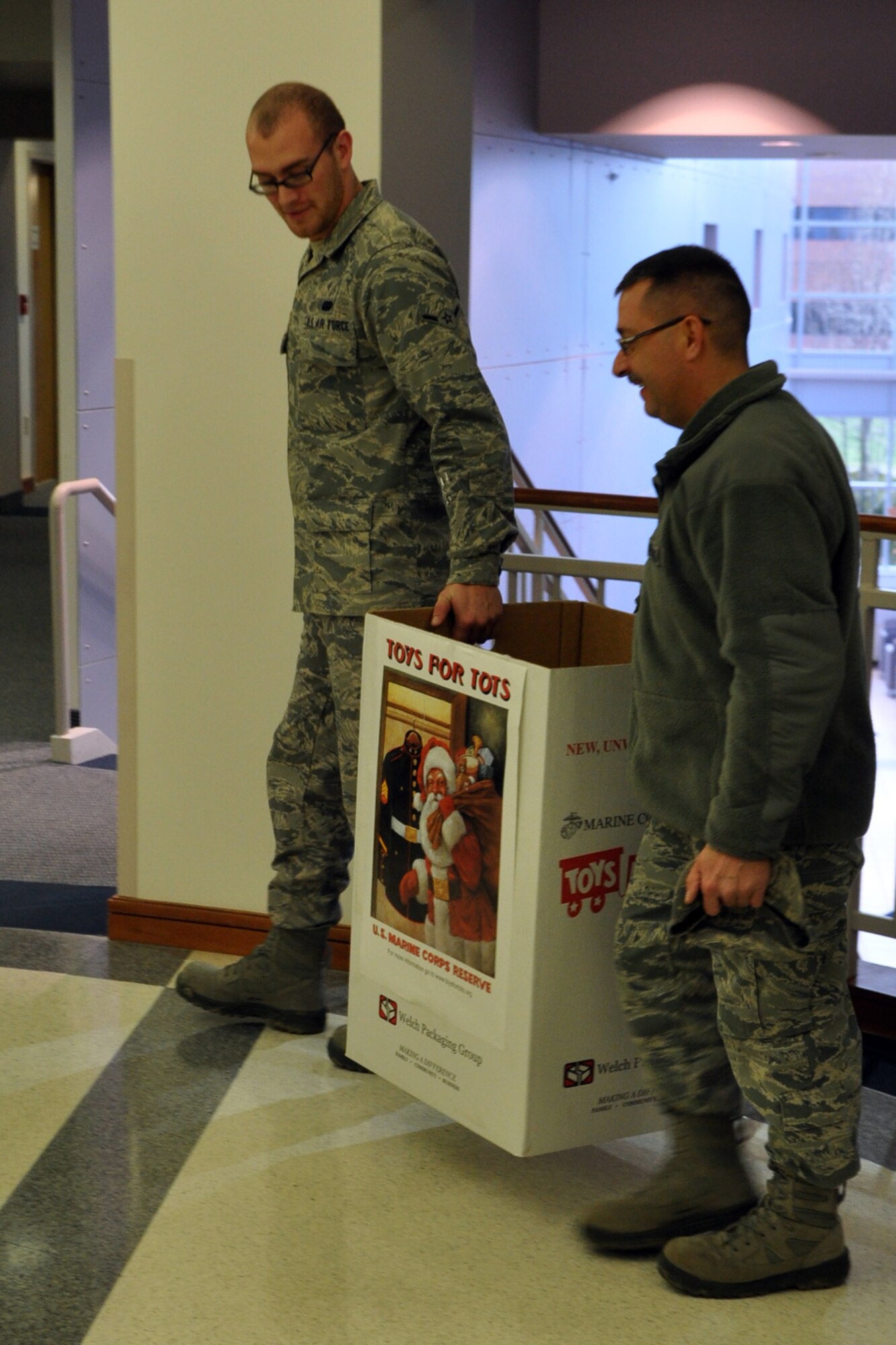 YOUNGSTOWN AIR RESERVE STATION, Ohio – Air Force Reserve Tech. Sgt. Duane Cribley (right), a utilities specialist, and Airman Matthew Fenton, an administration specialist, both assigned to the 910th Civil Engineer Squadron, pick up a Toys for Tots collection box at the 910th Airlift Wing Headquarters building here, Dec. 9, 2011. The wing annually partners with the Marine Corps Reserve unit based here, to collect new, un-wrapped toys for area boys and girls (newborn through 16 years of age) in order to provide a gift for Christmas morning that the children might otherwise not receive. U.S. Air Force photo by Master Sgt. Bob Barko Jr.