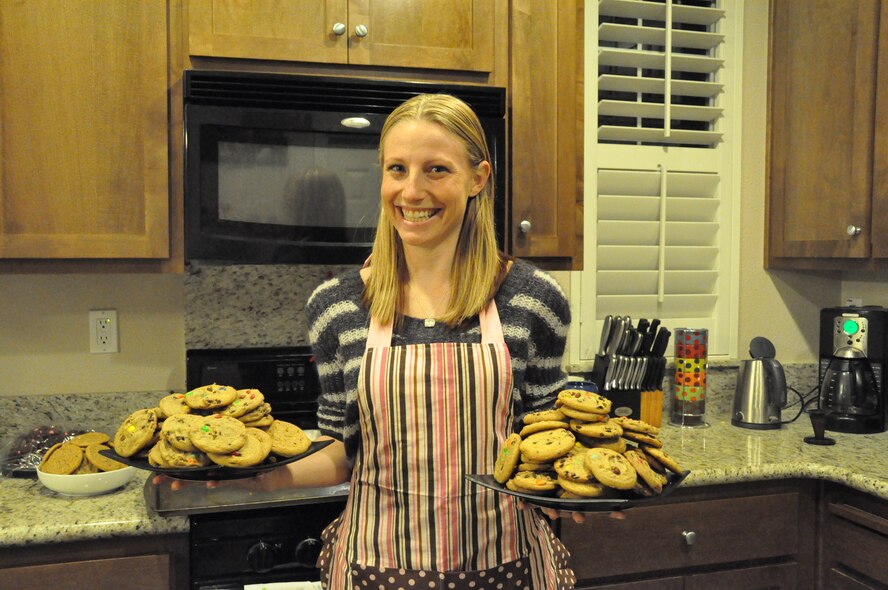 Kate Slawski holds two plates of cookies Tuesday that she has prepared to donate to Airmen in the dorms in support of Operation Cookie Drop. Slawski made approximately 275 cookies and plans on baking many more before donating. (U.S. Air Force photo/Airman Madelyn Ottem)