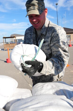 Senior Airman Matthew Parker moves sandbags to build a Defensive Fighting Position during the Operational Readiness Inspection at Gulfport, Miss. Dec. 2, 2011. More than 600 Airmen from Joint Base Charleston, S.C. simulated a deployment for the ORI. Parker is a security forces patrolman with 628th Security Forces Squadron. (U.S. Air Force photo/Staff Sgt. Katie Gieratz)(Released)