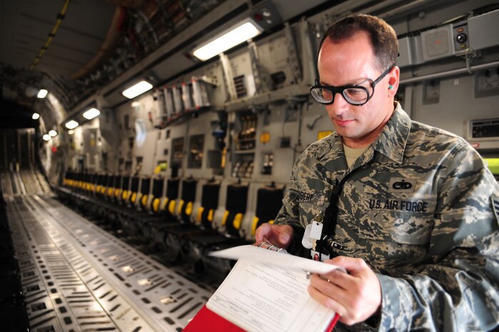 Technical Sgt. Jeffrey Dubert reviews a job guide prior to performing a pre-flight inspection on a C-17 at Gulfport, Miss. Dec. 2, 2011 during the Operational Readiness Inspection. Air Mobility Command’s Global Mobility concept of operations provides rapid global projection and sustainment of combat capability to support warfighting commanders. Dubert is a crew chief with the 315th Aircraft Maintenance Squadron. (U.S. Air Force photo/Staff Sgt. Katie Gieratz)